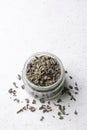 Jar of green tea on white surface, taken from above