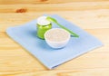 Jar vegetable puree, bowl porridge, spoon on background light wood.