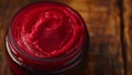 A jar of vibrant red herbal paste made from natural ingredients used for topical application and known for its