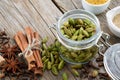 Jar of whole green cardamom pods and spices - cinnamon sticks, cardamom, allspices and anise. Ayurveda treatments Royalty Free Stock Photo