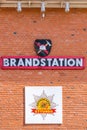 Exterior brick wall on a fire station with signs and text.