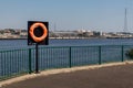 River view showing orange life bouy by railings Royalty Free Stock Photo