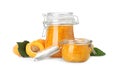 Jars of apricot jam and fresh fruits on white background