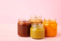 Jars of baby puree on pink background. Fruit and vegetables puree Royalty Free Stock Photo