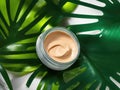 cosmetic body or face cream on green plant leaves as background. Natural eco beauty skin care concept, ai generative