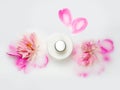 Jars of cream and pink peonys in a milk bath. Natural cosmetics. Conceptual photo: the best cosmetic tool for body and face care.