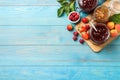 Jars with different jams and fresh fruits on light blue wooden table, flat lay. Space for text Royalty Free Stock Photo