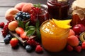 Jars with different jams and fresh fruits on wooden table, closeup Royalty Free Stock Photo