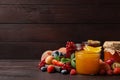 Jars with different jams and fresh fruits on wooden table. Space for text Royalty Free Stock Photo