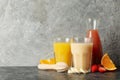 Jars with different juices against gray background