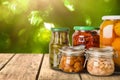 Jars of different pickled foods on wooden table against blurred background, space for text Royalty Free Stock Photo