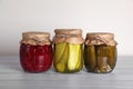 Jars with different preserved vegetables on wooden table Royalty Free Stock Photo