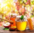 Jars full of fresh honey and honeycombs. Colorful nature background