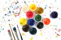 Jars with gouache paints and brushes on colorful paint splashes background. Royalty Free Stock Photo