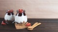 Jars of granola with yogurt, strawberry jam and fresh strawberries on a brown wooden background with copy space Royalty Free Stock Photo