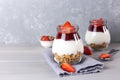 Jars of granola with yogurt, strawberry jam and fresh strawberries on a gray wooden background. Healthy breakfast Royalty Free Stock Photo