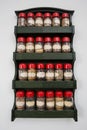 Jars of herbs and spices in wooden rack on white background, vintage design Royalty Free Stock Photo