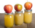 Jars of homemade applesauce with apples