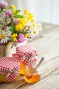 Jars of honey and healing herbs bunch on table. Royalty Free Stock Photo
