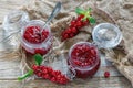 Jars of jam red currant, green mint and old sacking. Royalty Free Stock Photo