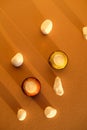 Jars of moisturizer creams and stones on brown background on sunset. Flat lay, top view