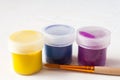 Jars with multi-colored gouache or acrylic paints on a light white background with a brush. Selective soft fokus. Text copy space Royalty Free Stock Photo