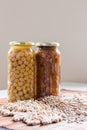 Jars of non-perishable chickpeas and lentils with spilled seeds on the table purchased