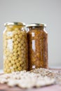 Jars of non-perishable chickpeas and lentils with spilled seeds on the table