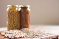 Jars of non-perishable chickpeas and lentils with spilled seeds on the table