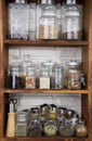 Jars with nuts, dried fruits, spices, herbs and others on kitchen shelves