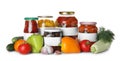Jars of pickled products and fresh vegetables on background Royalty Free Stock Photo