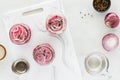 Jars prepared with pickled red onions, on a white cutting board. Royalty Free Stock Photo