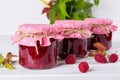 Jars with raspberry jam placed in rows and fresh raspberry Royalty Free Stock Photo