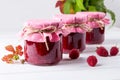 Jars with raspberry jam placed in rows and fresh raspberry Royalty Free Stock Photo