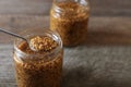 Jars and spoon of whole grain mustard on wooden table, closeup. Space for text Royalty Free Stock Photo