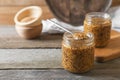 Jars and spoon of whole grain mustard on wooden table. Space for text Royalty Free Stock Photo