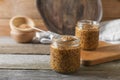 Jars and spoon of whole grain mustard on wooden table. Space for text Royalty Free Stock Photo