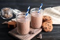 Jars with tasty chocolate milk on wooden table Royalty Free Stock Photo