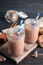 Jars with tasty chocolate milk on wooden table Royalty Free Stock Photo