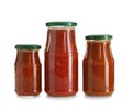 Jars with tasty sauces on white background