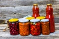 Jars with variety of canned vegetables and fruits, jars with zacusca and bottles with tomatoes sauce. Preserved food concept in a