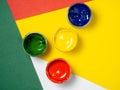 Jars with yellow, green and red paint on a color pepper. Banks of gouache. Traffic lights. Creative background.