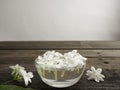 Jasmine floating in clear glass on wooden background