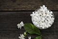 Jasmine floating in clear glass on wooden background