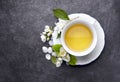 Jasmine flowers and cup of healthy tea, herbal medicine. A cup of green tea with jasmine on a black background Royalty Free Stock Photo