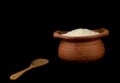 Jasmine rice in a clay pot and the wood ladle on white background Royalty Free Stock Photo