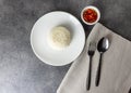Jasmine rice serve on a plate with spoon and fork in restaurant, plate of steamed white rice