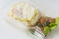 Jasmine rice with spicy pork fried with hot basil and fried egg in a transparent plastic box package Royalty Free Stock Photo