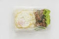 Jasmine rice with spicy pork fried with hot basil and fried egg in a transparent plastic box package Royalty Free Stock Photo