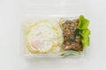 Jasmine rice with spicy pork fried with hot basil and fried egg in a transparent plastic box package Royalty Free Stock Photo